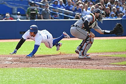 Jul 30, 2022; Toronto, Ontario, CAN; Toronto Blue Jays designated hitter George Springer (4) dives past Detroit Tigers catcher Eric Haase (13) to score in the sixth inning after a Toronto Blue Jays short stop Bo Bichette (11) (not shown) sacrifice fly at Rogers Centre. Mandatory Credit: Gerry Angus-USA TODAY Sports