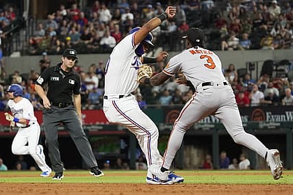 Aug 2, 2022; Arlington, Texas, USA; Texas Rangers catcher Meibrys Viloria (60) is tagged out by Baltimore Orioles shortstop Jorge Mateo (3) after being caught in a run down between second and third base during the second inning at Globe Life Field. Mandatory Credit: Raymond Carlin III-USA TODAY Sports
