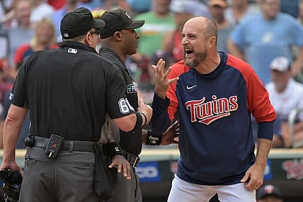 Aug 7, 2022; Minneapolis, Minnesota, USA; Minnesota Twins manager Rocco Baldelli (5) reacts with umpire Marty Foster (60) and umpire Alan Porter (64) to an overturned call during the tenth inning at Target Field. Mandatory Credit: Jeffrey Becker-USA TODAY Sports