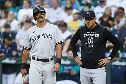 Aug 8, 2022; Seattle, Washington, USA; New York Yankees designated hitter Matt Carpenter (left) reacts while manager Aaron Boone (right) watches after a foul ball struck his foot during the first inning against the Seattle Mariners at T-Mobile Park. Mandatory Credit: Joe Nicholson-USA TODAY Sports