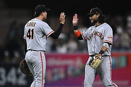 Aug 8, 2022; San Diego, California, USA; San Francisco Giants shortstop Brandon Crawford (right) and first baseman Wilmer Flores (41) celebrate after defeating the San Diego Padres at Petco Park. Mandatory Credit: Orlando Ramirez-USA TODAY Sports