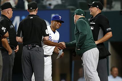 Aug 15, 2022; Arlington, Texas, USA; Texas Rangers interim manager Tony Beasley (27) shakes hands with Oakland Athletics manager Mark Kotsay (7) and the umpiring crew before a game at Globe Life Field. Mandatory Credit: Tim Heitman-USA TODAY Sports