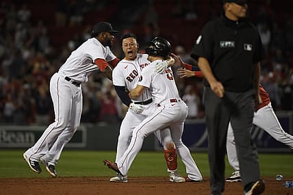 Sep 1, 2022; Boston, Massachusetts, USA; Boston Red Sox center fielder Rob Refsnyder (30) is mobbed by center fielder Enrique Hernandez (5) and first baseman Franchy Cordero (16) after hitting a walk off single during the ninth inning against the Texas Rangers at Fenway Park. Mandatory Credit: Bob DeChiara-USA TODAY Sports