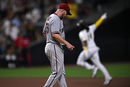 Sep 6, 2022; San Diego, California, USA; San Diego Padres designated hitter Josh Bell (right) gestures while rounding the bases after hitting a home run against Arizona Diamondbacks starting pitcher Merrill Kelly (29) during the seventh inning at Petco Park. Mandatory Credit: Orlando Ramirez-USA TODAY Sports