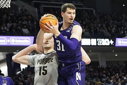 Feb 16, 2022; Evanston, Illinois, USA; Northwestern Wildcats forward Robbie Beran (31) grabs a rebound in front of Purdue Boilermakers center Zach Edey (15) during the first half at Welsh-Ryan Arena. Mandatory Credit: David Banks-USA TODAY Sports
