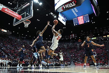Nov 7, 2022; San Diego, California, USA; San Diego State Aztecs guard Matt Bradley (20) shoots the ball over Cal State Fullerton Titans guard Tory San Antonio (23) during the first half at Viejas Arena. Mandatory Credit: Orlando Ramirez-USA TODAY Sports