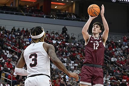 Nov 9, 2022; Louisville, Kentucky, USA;  Bellarmine Knights forward Langdon Hatton (12) shoots against Louisville Cardinals guard El Ellis (3) during the first half at KFC Yum! Center. Mandatory Credit: Jamie Rhodes-USA TODAY Sports