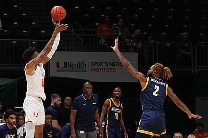 Nov 11, 2022; Coral Gables, Florida, USA; Miami Hurricanes guard Jordan Miller (11) attempts a three point shot over UNC Greensboro Spartans forward Mikeal Brown-Jones (2) during the first half at Watsco Center. Mandatory Credit: Jasen Vinlove-USA TODAY Sports