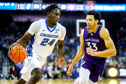 Nov 14, 2022; Omaha, Nebraska, USA; Creighton Bluejays forward Arthur Kaluma (24) drives to the hoop against Holy Cross Crusaders forward Caleb Kenney (33) during the first half at CHI Health Center Omaha. Mandatory Credit: Dylan Widger-USA TODAY Sports