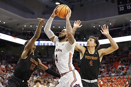 Nov 15, 2022; Auburn, Alabama, USA;  Auburn Tigers forward Johni Broome (4) takes a shot between Winthrop Eagles forwards Cory Hightower (12) and Kelton Talford (4) during the second half against at Neville Arena. Mandatory Credit: John Reed-USA TODAY Sports