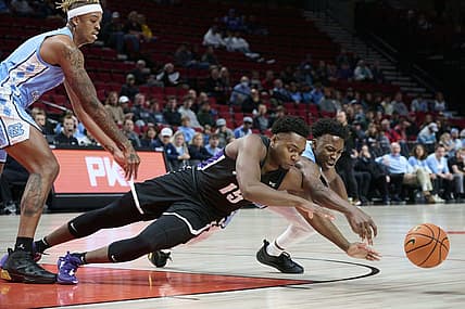 Nov 24, 2022; Portland, Oregon, USA; Portland Pilots forward Chika Nduka (15) and North Carolina Tar Heels guard D'Marco Dunn (11) dive for the ball during the first half at Moda Center. Mandatory Credit: Troy Wayrynen-USA TODAY Sports