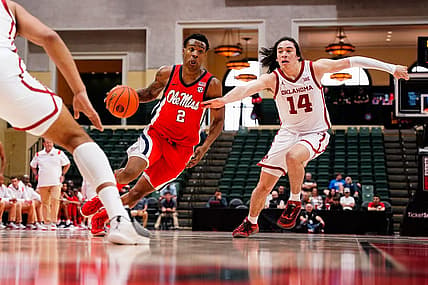 Nov 27, 2022; Orlando, FL, USA; Mississippi Rebels guard TJ Caldwell (2) dribbles past Oklahoma Sooners guard Bijan Cortes (14) during the first half at ESPN Wide World of Sports. Mandatory Credit: Rich Storry-USA TODAY Sports