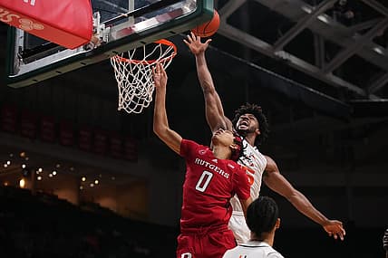 Nov 30, 2022; Coral Gables, Florida, USA; Miami Hurricanes forward Norchad Omier (15) blocks the shot of Rutgers Scarlet Knights guard Derek Simpson (0) during the first half at Watsco Center. Mandatory Credit: Jasen Vinlove-USA TODAY Sports