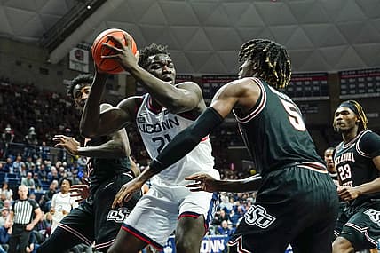 Dec 1, 2022; Storrs, Connecticut, USA; Connecticut Huskies forward Adama Sanogo (21) controls the ball against Oklahoma State Cowboys guard Caleb Asberry (5) during the first half at Harry A. Gampel Pavilion. Mandatory Credit: Gregory Fisher-USA TODAY Sports