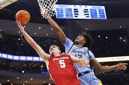 Dec 3, 2022; Milwaukee, Wisconsin, USA;  Wisconsin Badgers forward Tyler Wahl (5) shoots against Marquette Golden Eagles forward Olivier-Maxence Prosper (12) during the first half at Fiserv Forum. Mandatory Credit: Jeff Hanisch-USA TODAY Sports