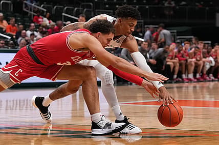 Dec 7, 2022; Coral Gables, Florida, USA; Miami Hurricanes guard Jordan Miller (11) and Cornell Big Red guard Chris Manon (30) battle for a loose ball during the first half at Watsco Center. Mandatory Credit: Jasen Vinlove-USA TODAY Sports