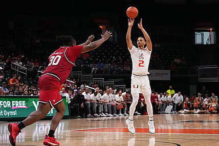 Dec 10, 2022; Coral Gables, Florida, USA; Miami Hurricanes guard Isaiah Wong (2) attempts a three point shot over North Carolina State Wolfpack forward D.J. Burns Jr. (30) during the second half at Watsco Center. Mandatory Credit: Jasen Vinlove-USA TODAY Sports