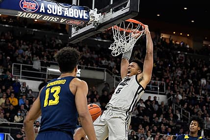 Dec 20, 2022; Providence, Rhode Island, USA; Providence Friars forward Ed Croswell (5) hangs from the basket after scoring against the Marquette Golden Eagles during the first half at Amica Mutual Pavilion. Mandatory Credit: Eric Canha-USA TODAY Sports