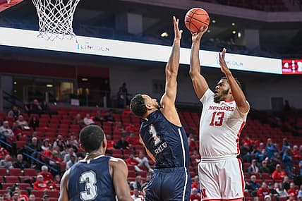 Dec 20, 2022; Lincoln, Nebraska, USA;  Nebraska Cornhuskers forward Derrick Walker (13) scores over Queens Royals forward Mike Fowler (1) in the first half at Pinnacle Bank Arena. Mandatory Credit: Steven Branscombe-USA TODAY Sports