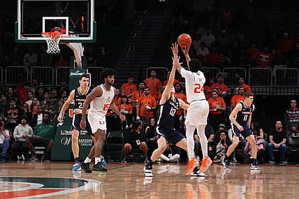 Dec 20, 2022; Coral Gables, Florida, USA; Miami Hurricanes guard Nijel Pack (24) attempts a three point shot over Virginia Cavaliers guard Taine Murray (10) during the first half at Watsco Center. Mandatory Credit: Jasen Vinlove-USA TODAY Sports