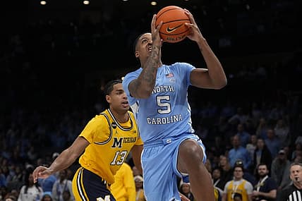 Dec 21, 2022; Charlotte, North Carolina, USA; North Carolina Tar Heels forward Armando Bacot (5) drives to the basket past Michigan Wolverines guard Jett Howard (13) during the first half at the Jumpman Classic at the Spectrum Center. Mandatory Credit: Jim Dedmon-USA TODAY Sports
