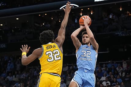 Dec 21, 2022; Charlotte, North Carolina, USA; North Carolina Tar Heels forward Pete Nance (32) shoots over Michigan Wolverines forward Tarris Reed Jr. (32) during the first half at the Jumpman Classic at the Spectrum Center. Mandatory Credit: Jim Dedmon-USA TODAY Sports