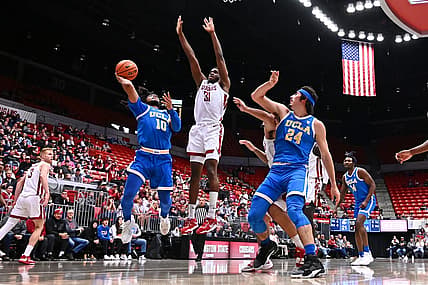 Dec 30, 2022; Pullman, Washington, USA; UCLA Bruins guard Tyger Campbell (10) shoots the ball against Washington State Cougars guard Kymany Houinsou (31) in the first half at Friel Court at Beasley Coliseum. Mandatory Credit: James Snook-USA TODAY Sports