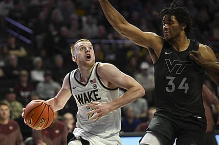 Dec 31, 2022; Winston-Salem, North Carolina, USA; Wake Forest Demon Deacons guard Cameron Hildreth (2) drives around Virginia Tech Hokies forward Mylyjael Poteat (34) during the first half at Lawrence Joel Veterans Memorial Coliseum. Mandatory Credit: William Howard-USA TODAY Sports
