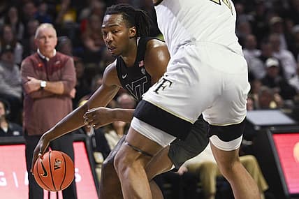 Dec 31, 2022; Winston-Salem, North Carolina, USA; Virginia Tech Hokies forward Justyn Mutts (25) dribbles around Wake Forest Demon Deacons forward Davion Bradford (20) during the second half at Lawrence Joel Veterans Memorial Coliseum. Mandatory Credit: William Howard-USA TODAY Sports