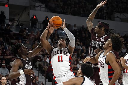 Jan 7, 2023; Starkville, Mississippi, USA; Mississippi Rebels guard Matthew Murrell (11) shoots as Mississippi State Bulldogs guard/forward Cameron Matthews (4) fouls him during the first half at Humphrey Coliseum. Mandatory Credit: Petre Thomas-USA TODAY Sports