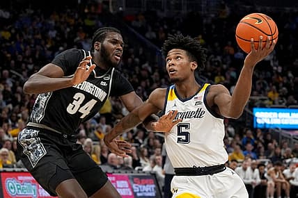 Jan 7, 2023; Milwaukee, Wisconsin, USA; Marquette Golden Eagles guard Chase Ross (5) drives past Georgetown Hoyas center Qudus Wahab (34) during the first half of their game at Fiserv Forum. Mandatory Credit: Mark Hoffman-USA TODAY Sports