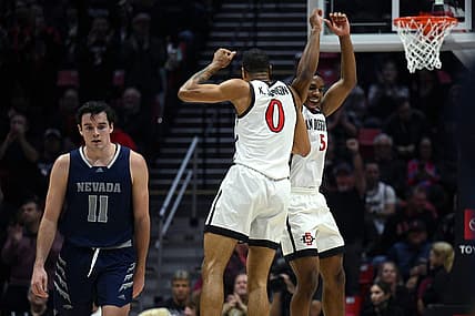 Jan 10, 2023; San Diego, California, USA; San Diego State Aztecs forward Keshad Johnson (0) and guard Lamont Butler (5) celebrate as Nevada Wolf Pack forward Nick Davidson (11) looks on during the first half at Viejas Arena. Mandatory Credit: Orlando Ramirez-USA TODAY Sports