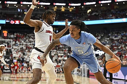 Jan 14, 2023; Louisville, Kentucky, USA;  North Carolina Tar Heels forward Armando Bacot (5) dribbles the ball against Louisville Cardinals forward Roosevelt Wheeler (4) during the first half at KFC Yum! Center. Mandatory Credit: Jamie Rhodes-USA TODAY Sports