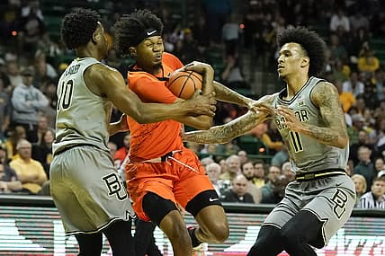 Jan 14, 2023; Waco, Texas, USA; Oklahoma State Cowboys guard Woody Newton (4) drives past Baylor Bears guard Adam Flagler (10) and forward Jalen Bridges (11) during the first half at Ferrell Center. Mandatory Credit: Raymond Carlin III-USA TODAY Sports