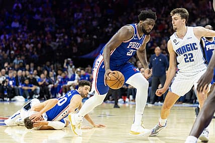Jan 30, 2023; Philadelphia, Pennsylvania, USA; Philadelphia 76ers center Joel Embiid (21) dribbles the ball after a pass from Georges Niang (20) against Orlando Magic center Moritz Wagner (21) in front of forward Franz Wagner (22) during the fourth quarter at Wells Fargo Center. Mandatory Credit: Bill Streicher-USA TODAY Sports
