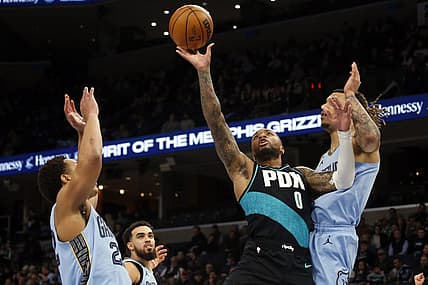 Feb 1, 2023; Memphis, Tennessee, USA; Portland Trail Blazers guard Damian Lillard (0) moves to the basket as Memphis Grizzlies guard Desmond Bane (22) and Memphis Grizzlies forward Brandon Clark (15) defend during the first half at FedExForum. Mandatory Credit: Petre Thomas-USA TODAY Sports