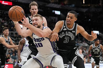 Feb 1, 2023; San Antonio, Texas, USA;  Sacramento Kings forward Domantas Sabonis (10) reaches for a ball in front of San Antonio Spurs forward Keldon Johnson (3) in the second half at the AT&T Center. Mandatory Credit: Daniel Dunn-USA TODAY Sports