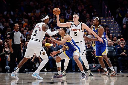 Feb 2, 2023; Denver, Colorado, USA; Denver Nuggets center Nikola Jokic (15) controls the ball against Golden State Warriors forward Kevon Looney (5) as guard Kentavious Caldwell-Pope (5) and guard Jordan Poole (3) battle for position in the first quarter at Ball Arena. Mandatory Credit: Isaiah J. Downing-USA TODAY Sports