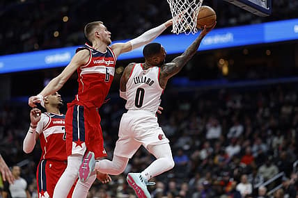 Feb 3, 2023; Washington, District of Columbia, USA; Portland Trail Blazers guard Damian Lillard (0) shoots the ball as Washington Wizards center Kristaps Porzingis (6) defends in the second quarter at Capital One Arena. Mandatory Credit: Geoff Burke-USA TODAY Sports