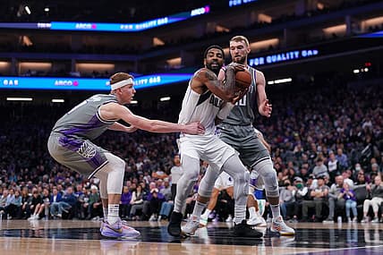 Feb 10, 2023; Sacramento, California, USA; Dallas Mavericks guard Kyrie Irving (2) holds onto a rebound between Sacramento Kings guard Kevin Huerter (9) and forward Domantas Sabonis (10) in the second quarter at the Golden 1 Center. Mandatory Credit: Cary Edmondson-USA TODAY Sports
