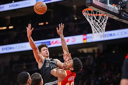 Feb 11, 2023; Atlanta, Georgia, USA; San Antonio Spurs forward Isaiah Roby (18) shoots over Atlanta Hawks forward De'Andre Hunter (12) in the second quarter at State Farm Arena. Mandatory Credit: Brett Davis-USA TODAY Sports