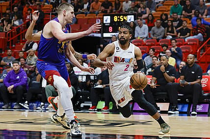 Feb 13, 2023; Miami, Florida, USA; Miami Heat guard Gabe Vincent (2) drives to the basket as Denver Nuggets center Nikola Jokic (15) defends during the first quarter at Miami-Dade Arena. Mandatory Credit: Sam Navarro-USA TODAY Sports