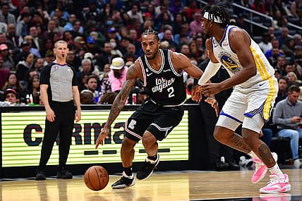 Feb 14, 2023; Los Angeles, California, USA; Los Angeles Clippers forward Kawhi Leonard (2) moves to the basket against Golden State Warriors forward Kevon Looney (5) during the first half at Crypto.com Arena. Mandatory Credit: Gary A. Vasquez-USA TODAY Sports