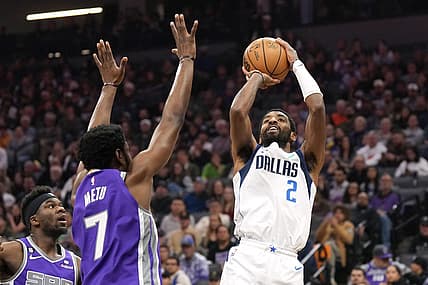 Feb 11, 2023; Sacramento, California, USA; Dallas Mavericks guard Kyrie Irving (2) shoots against Sacramento Kings forward Chimezie Metu (7) during the second quarter at Golden 1 Center. Mandatory Credit: Darren Yamashita-USA TODAY Sports