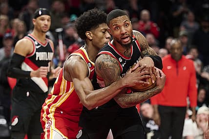 Jan 30, 2023; Portland, Oregon, USA; Atlanta Hawks forward De'Andre Hunter (12) fouls Portland Trail Blazers guard Damian Lillard (0) during the second half at Moda Center. Mandatory Credit: Troy Wayrynen-USA TODAY Sports