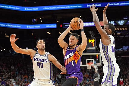 Mar 11, 2023; Phoenix, Arizona, USA; Phoenix Suns guard Devin Booker (1) drives against Sacramento Kings forward Trey Lyles (41) and Sacramento Kings forward Harrison Barnes (40) during the second half at Footprint Center. Mandatory Credit: Joe Camporeale-USA TODAY Sports