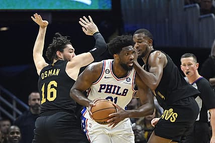 Mar 15, 2023; Cleveland, Ohio, USA; Philadelphia 76ers center Joel Embiid (21) looks to pass while defended by Cleveland Cavaliers forward Cedi Osman (16) and forward Evan Mobley (4) in the second quarter at Rocket Mortgage FieldHouse. Mandatory Credit: David Richard-USA TODAY Sports
