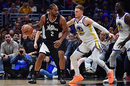 Mar 15, 2023; Los Angeles, California, USA; Los Angeles Clippers forward Kawhi Leonard (2) moves the ball against Golden State Warriors guard Donte DiVincenzo (0) during the first half at Crypto.com Arena. Mandatory Credit: Gary A. Vasquez-USA TODAY Sports