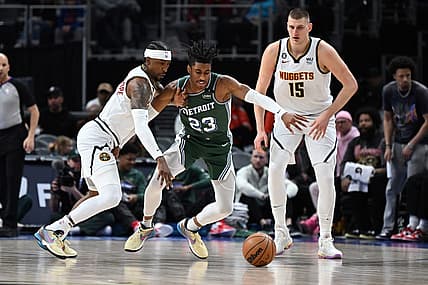 Mar 16, 2023; Detroit, Michigan, USA; Denver Nuggets guard Kentavious Caldwell-Pope (5) (left) knocks the ball away from Detroit Pistons guard Jaden Ivey (23) as Denver Nuggets center Nikola Jokic (15) watches in the first quarter at Little Caesars Arena. Mandatory Credit: Lon Horwedel-USA TODAY Sports