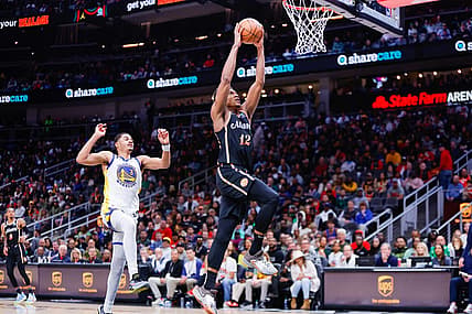 Mar 17, 2023; Atlanta, Georgia, USA; Atlanta Hawks forward De'Andre Hunter (12) dunks past Golden State Warriors guard Jordan Poole (3) in the second quarter at State Farm Arena. Mandatory Credit: Brett Davis-USA TODAY Sports